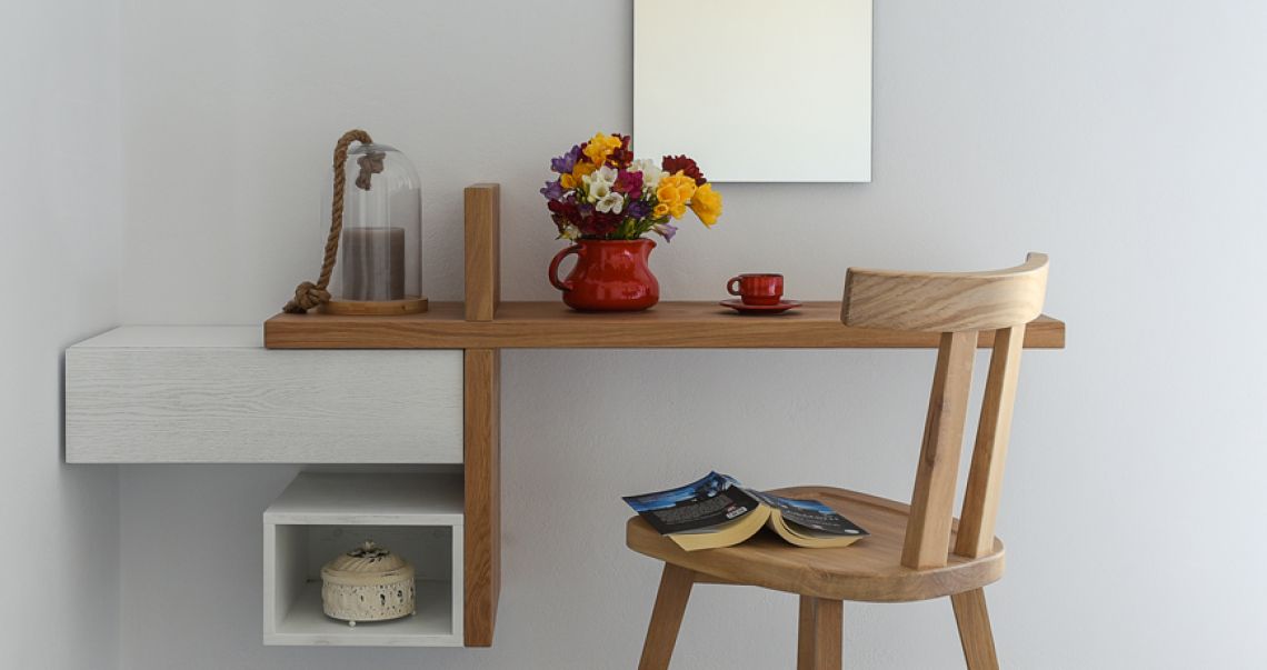 Detail of a wooden wall-mounted desk area decorated with a red vase of colorful flowers, a matching red espresso cup, and an open book.