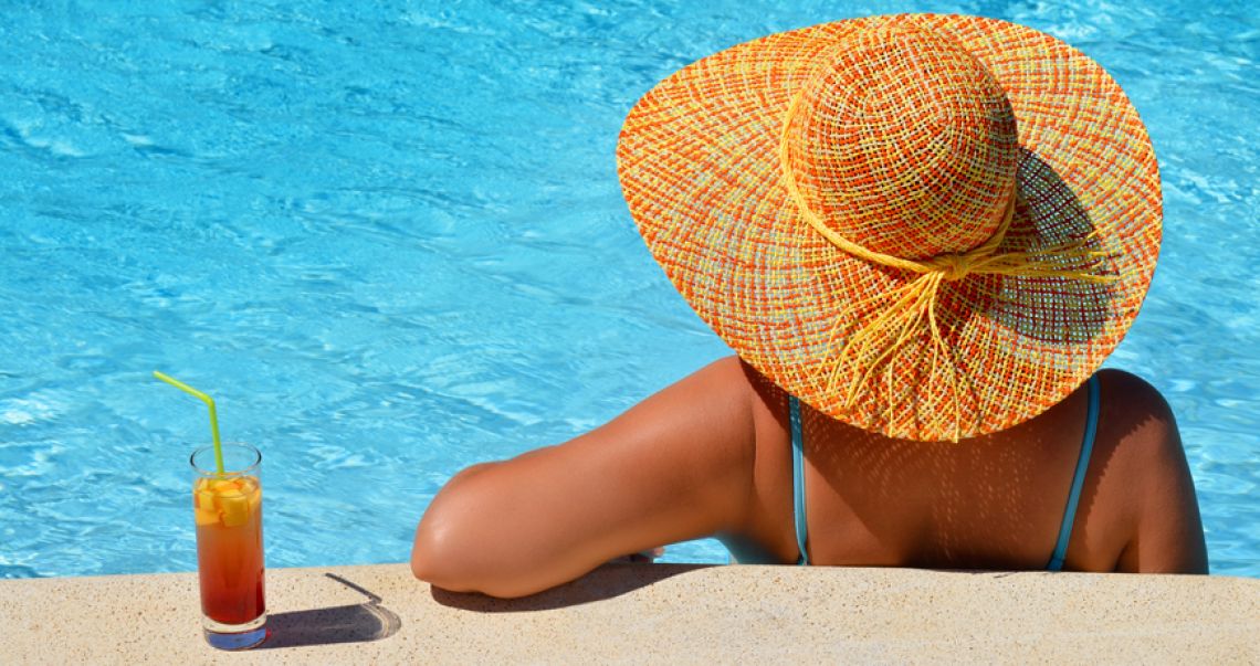 Woman enjoying a drink by the pool